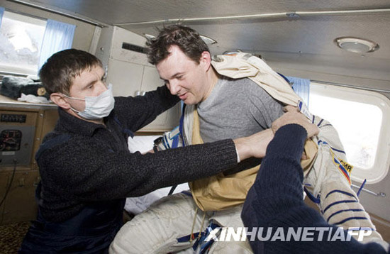 12月1日，俄罗斯宇航员罗曼·罗曼年科在哈萨克斯坦阿尔卡雷克附近着陆后在一辆车内脱下宇航服。新华社/法新