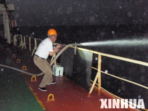 资料图：2009年5月20日，中国商船船员用水龙头抗击索马里海盗