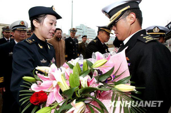 2010年3月8日，中国海军女兵向来访的新加坡海军军官献花。摄影：新华社记者陈飞