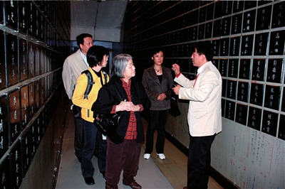 731部队罪证陈列馆馆长金成民（右一）向山边悠喜子（中）介绍731部队细菌战及人体实验受害者牌位。